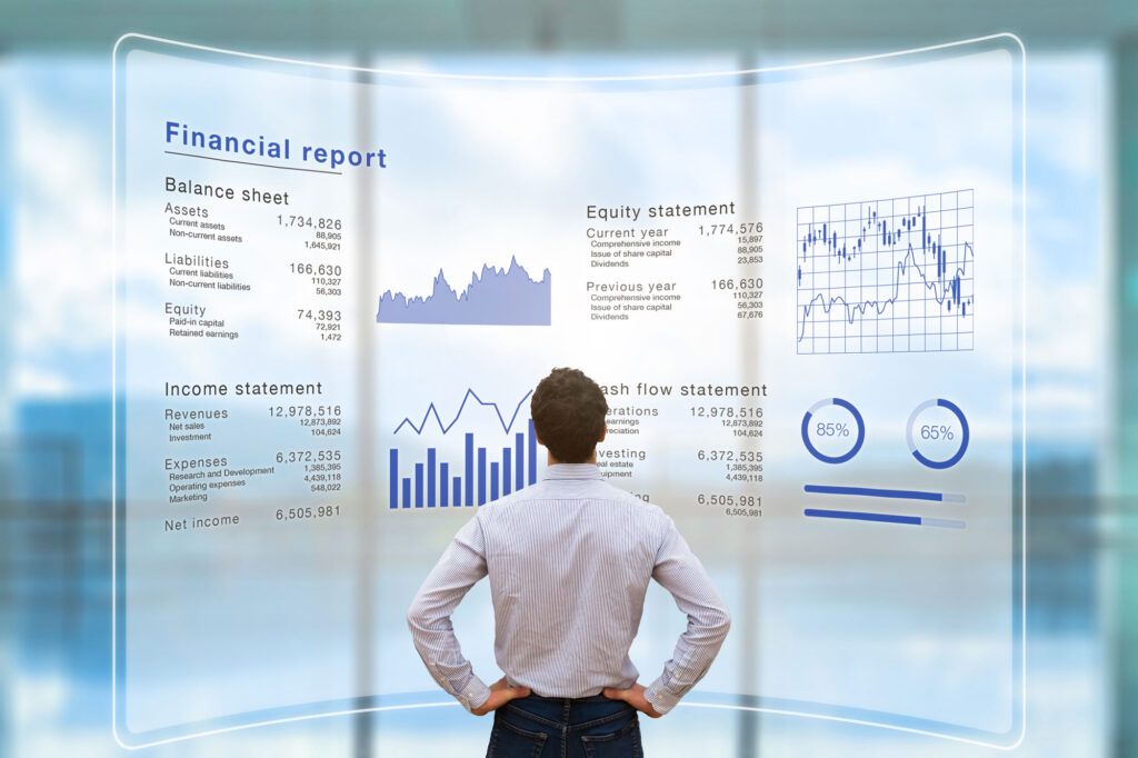 Person facing a transparent digital financial report display with charts and graphs, showing balance sheet, income, and cash flow statements.